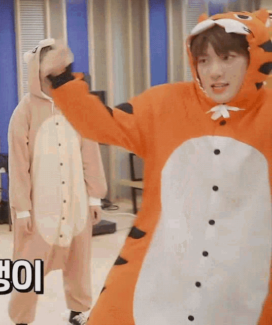 a boy in a tiger costume is standing next to another boy in a monkey costume .