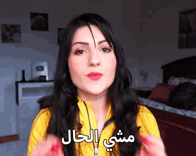 a woman wearing a yellow jacket with arabic writing on the front