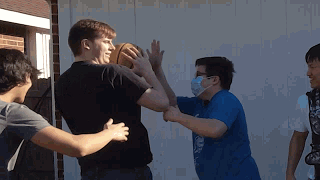 a man wearing a mask holds a basketball while another man holds his arm around him