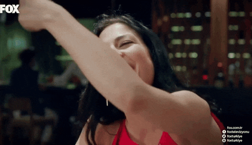 a woman in a red dress is dancing in front of a fox sign