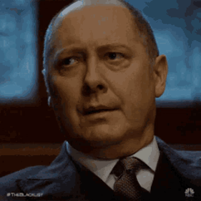 a man in a suit and tie is making a surprised face .