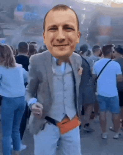 a man in a suit is standing in front of a crowd of people with his face on his chest .