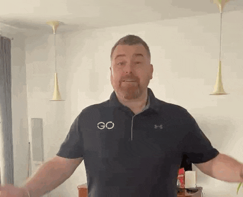 a man with a beard is wearing a blue under armour shirt .