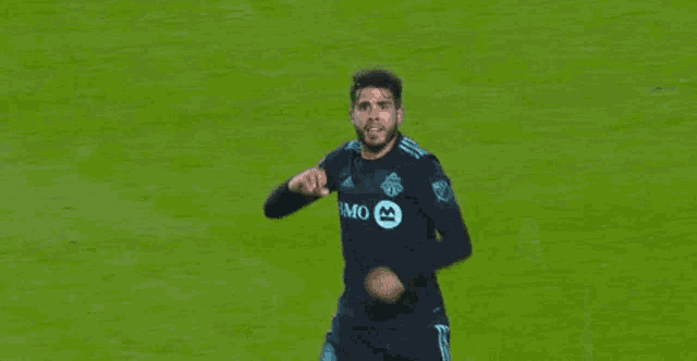 a man wearing a bmo jersey is running on a soccer field .