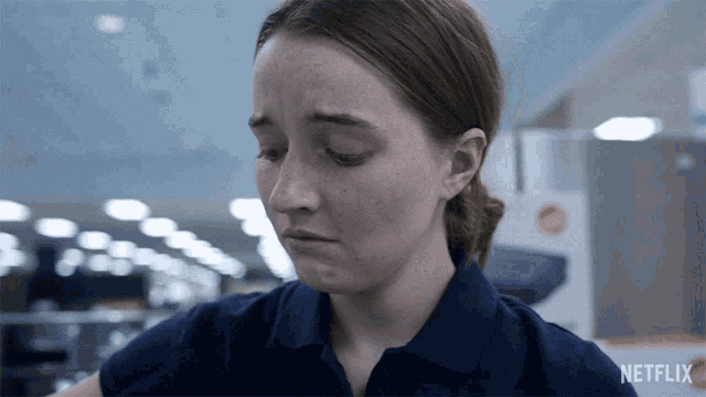 a woman in a blue shirt has a netflix logo on her shirt