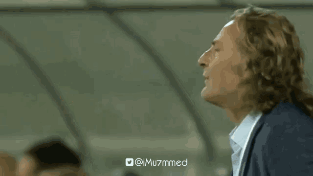 a man in a suit and white shirt is giving a thumbs up .