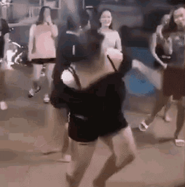 a group of people are dancing on a street in a dark room .