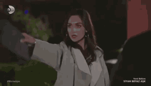 a woman in a white coat is pointing at a man in a red shirt .