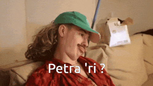 a man wearing a green hat and a red shirt says petra ' ri