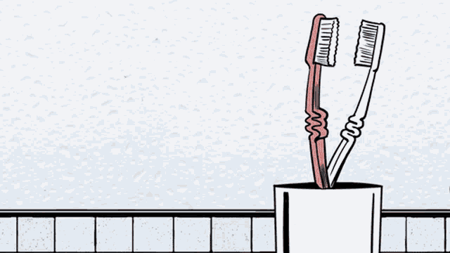 two toothbrushes in a cup on a tiled wall