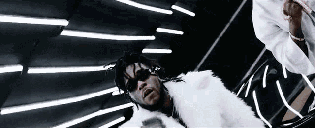 a man with dreadlocks wearing a white fur coat