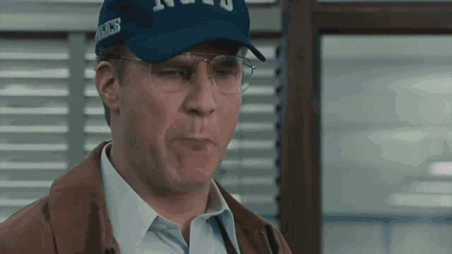 a man wearing glasses and a hat that says police