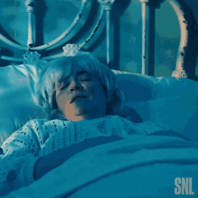 a woman is screaming in a bed with a snl logo in the corner