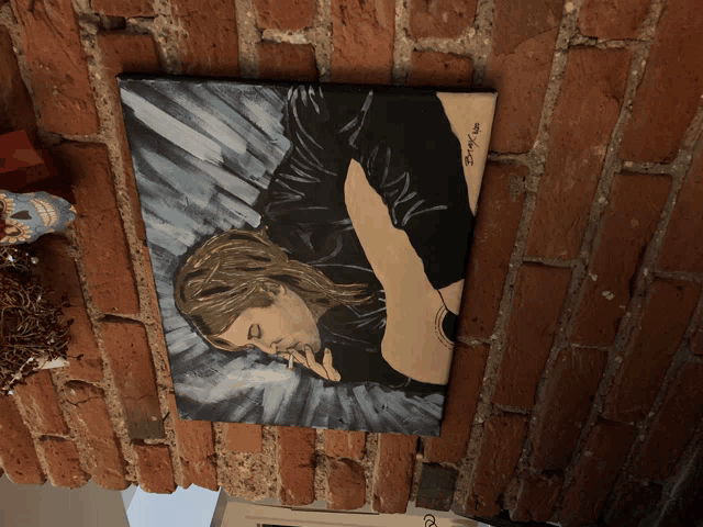 a painting on a brick wall shows a woman holding a guitar and the year 2008