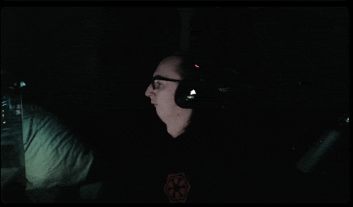 a man wearing headphones has a star wars logo on his sweatshirt