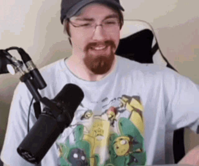 a man with a beard and glasses is smiling in front of a microphone that says fox