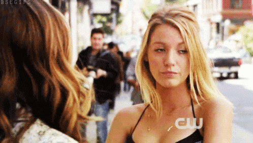 a woman wearing a black top and a necklace with the word cw on her chest