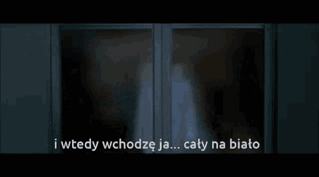 a man in a suit is standing in front of a window with the words i wtedy wchodze ja