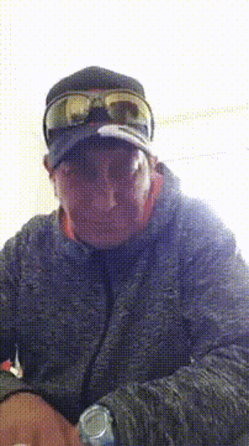 a man wearing a hat and goggles looks at the camera