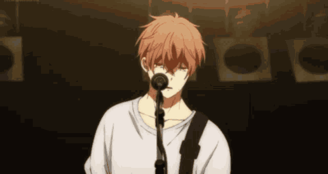 a man singing into a microphone with a guitar strap