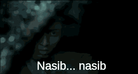 a close up of a person 's face behind a window with the words nasib ... nasib written on the bottom .