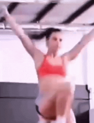 a woman in a red bra is doing exercises on a machine .