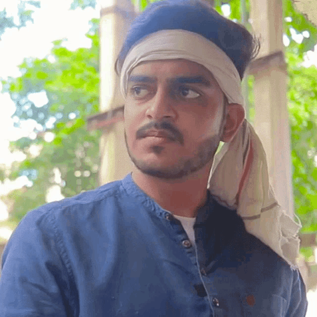 a man wearing a bandana around his head looks to the side