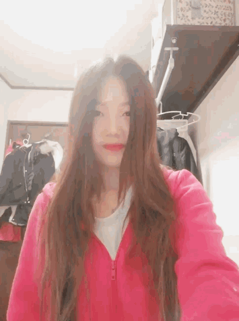 a woman wearing a pink jacket takes a selfie