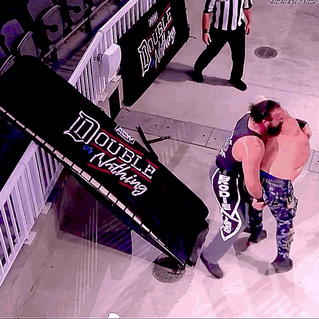 two men are wrestling in front of a double nothing banner