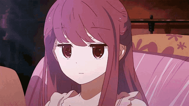 a cartoon girl with pink hair is sitting on a couch