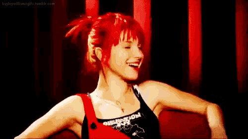 a pixelated image of a woman with red hair wearing a red tank top