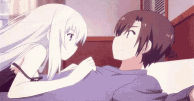 a boy and a girl are laying on a bed and kissing .