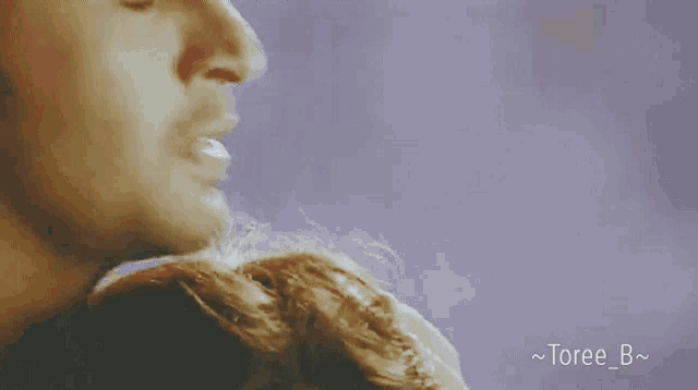 a close up of a man 's face with toree_b written on the bottom right