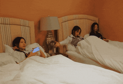 a woman laying on a bed holding a blue cell phone