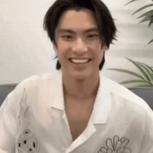 a close up of a man wearing a white shirt smiling .