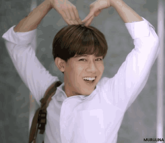 a young man making a heart shape with his hands