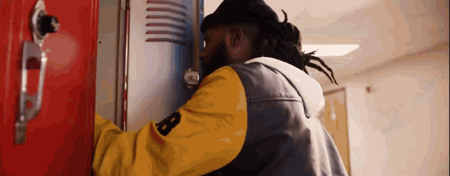 a man wearing a yellow jacket with the letter b on the sleeve