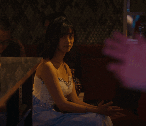 a woman in a white dress is sitting on a couch