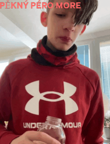 a boy wearing a red under armour hoodie