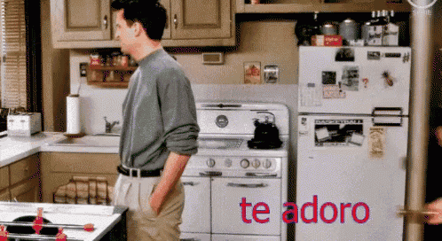 a man standing in a kitchen with the words te adoro on the bottom right
