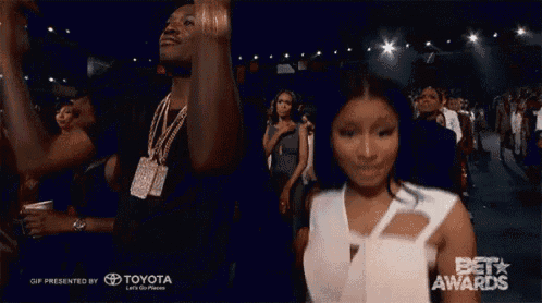 a woman in a white dress stands in front of a crowd at a bet awards show