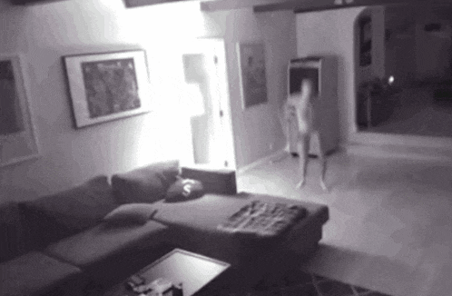 a black and white photo of a living room with a couch and a table