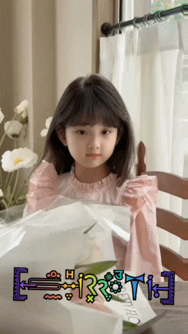 a little girl is sitting at a table with a sign that says " e = mc2 " on it