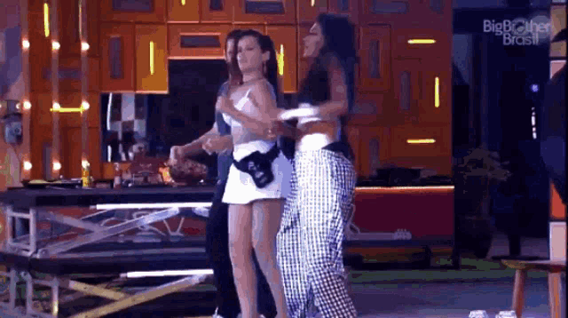 a group of women are standing next to each other on a stage in a room .