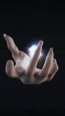 a person 's hand is holding a glowing object in it