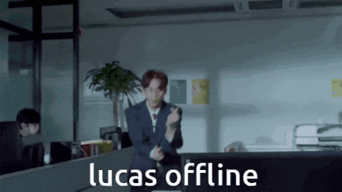 a man in a suit is giving the middle finger in an office with the words lucas offline below him
