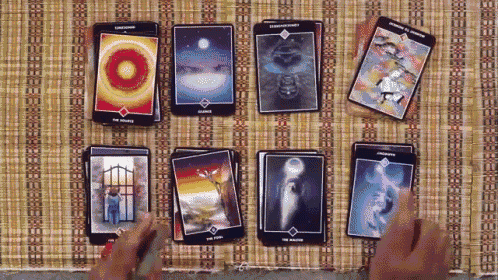 a person is playing a game of tarot with a stack of tarot cards on a table