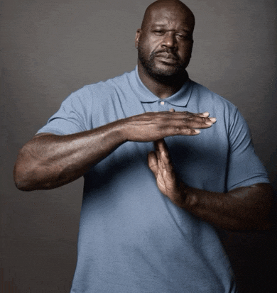 a man wearing a blue shirt is making a stop sign with his hands