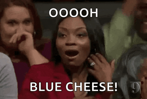 a woman is sitting in a crowd with her mouth open and screaming .