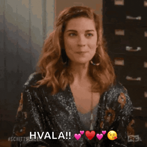 a woman in a sequined jacket is smiling and says hvala